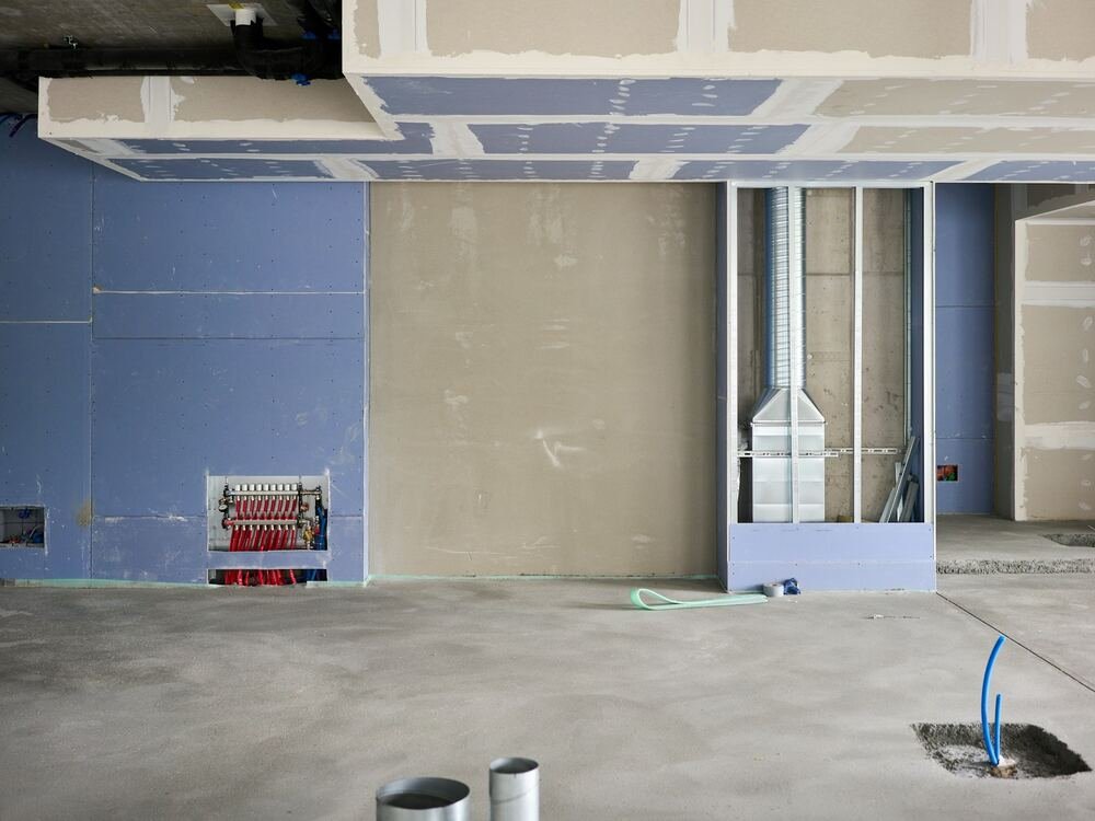 Teto falso em gesso cartonado em montagem, com estrutura e condutas.