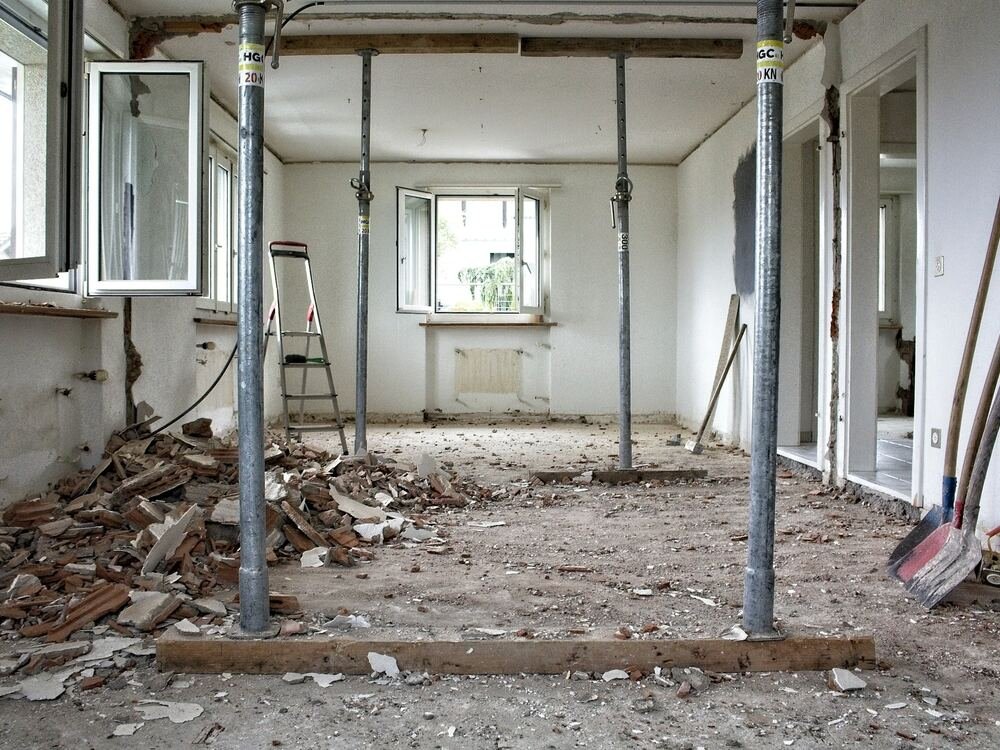 Divisão em obra com prumos metálicos a escorar o teto.
