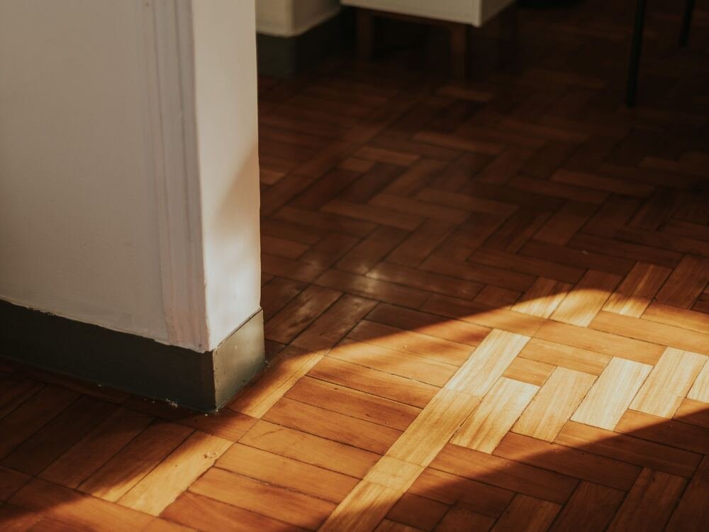 Luz do sol sobre soalho de madeira em espinha.