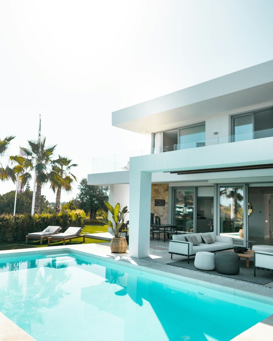 Moradia contemporânea com piscina de água azul e espreguiçadeiras.