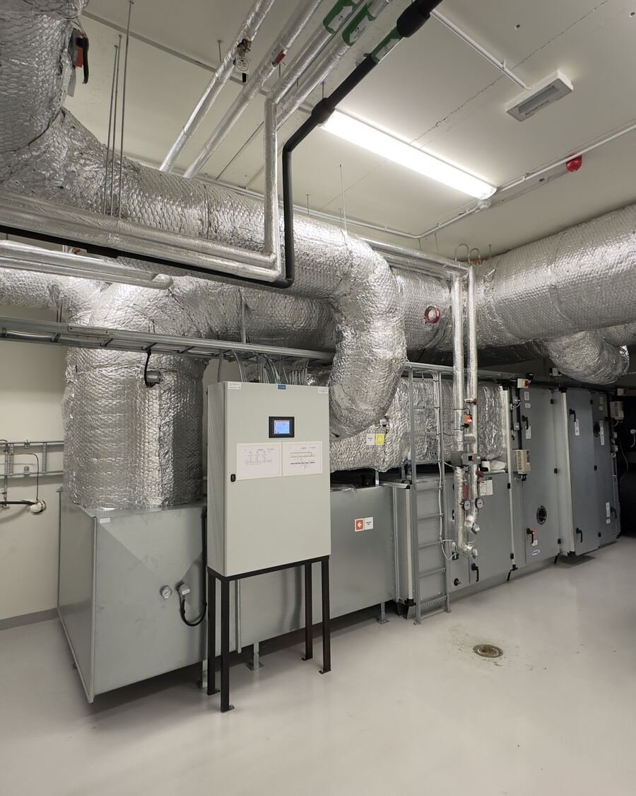Casa técnica com unidade de ventilação mecânica e condutas de ar isoladas no teto.